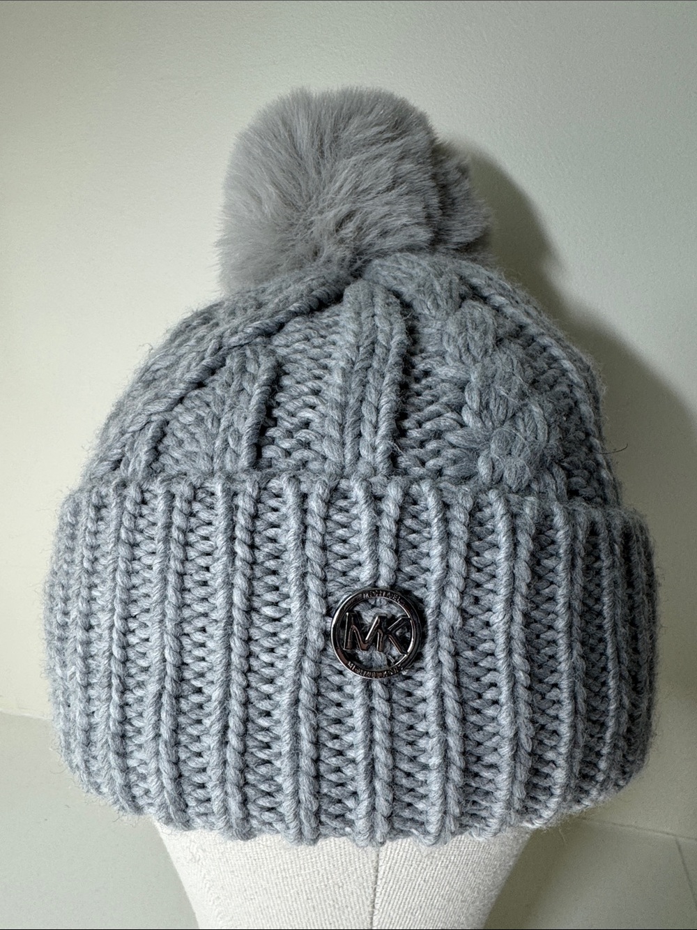 Michael Kors gray cableknit fleece-lined beanie with faux fur pompom.